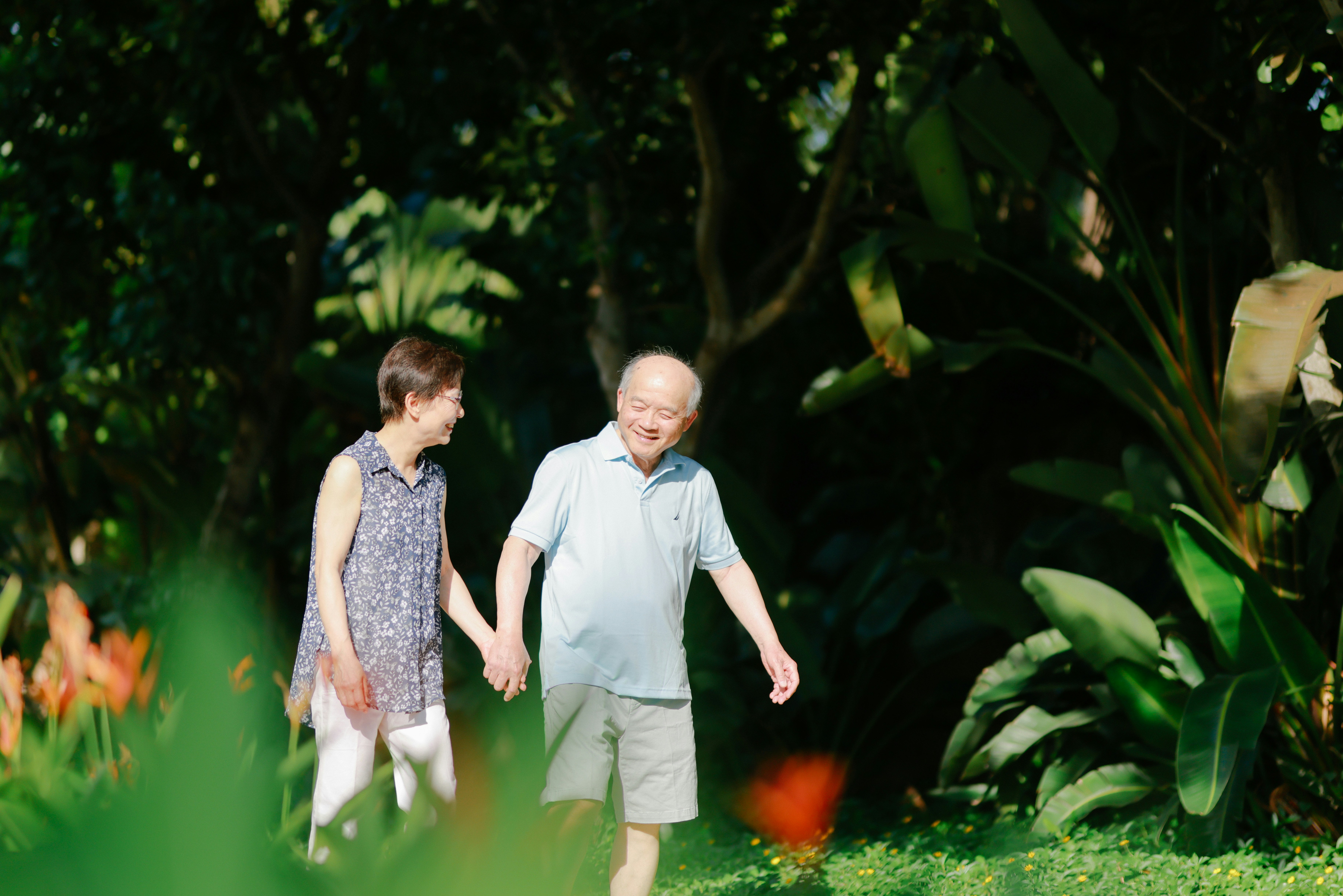 Two seniors enjoying a walk through a community garden in Victoria BC