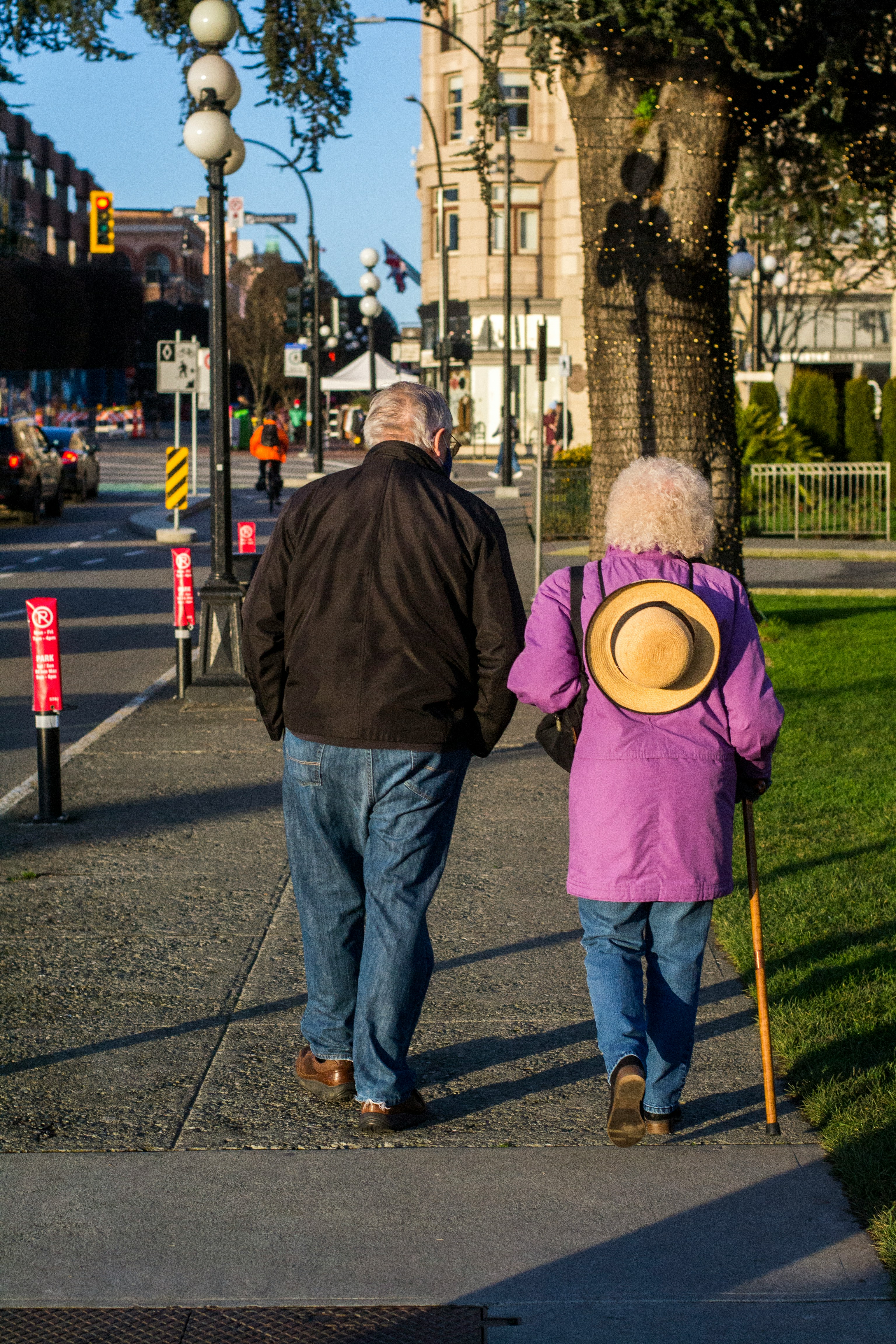 Active seniors walking together through a tree-lined street in downtown Victoria BC